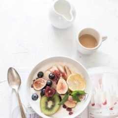 white ceramic plate beside gray steel spoon