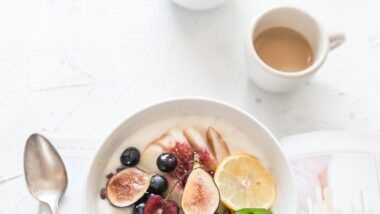 white ceramic plate beside gray steel spoon