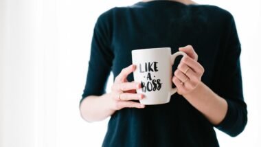 woman holding white mug while standing